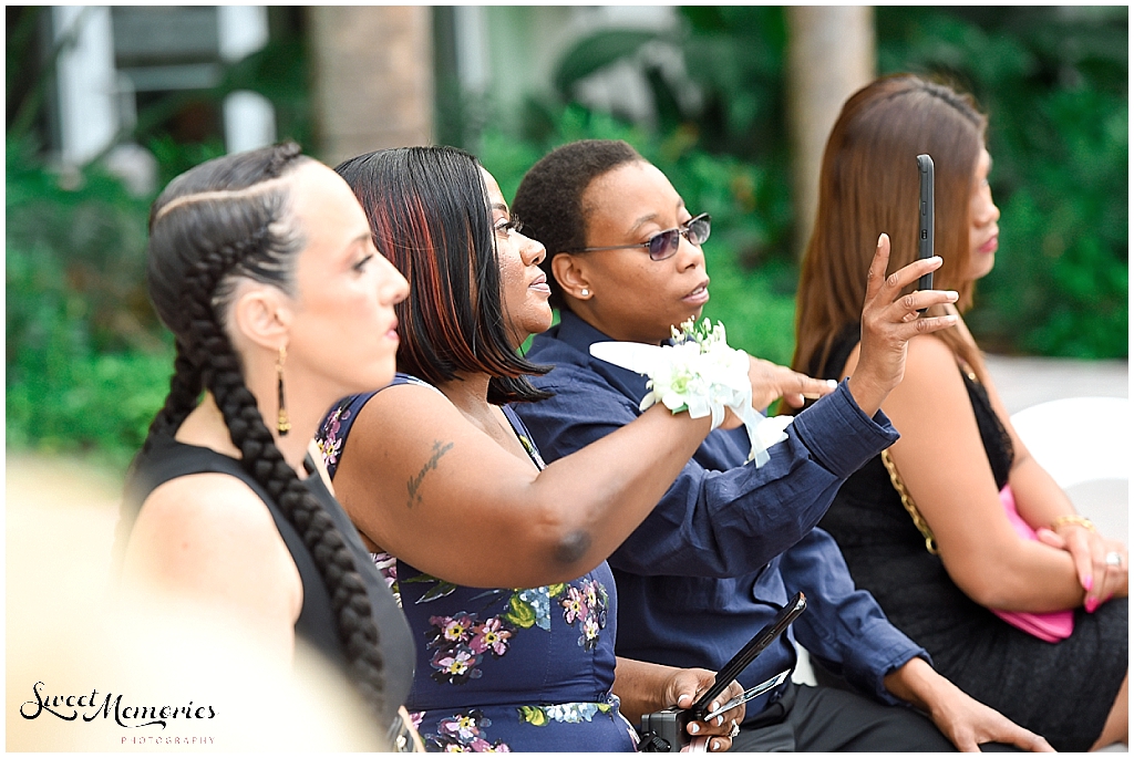 Monique's moms videoing the whole wedding ceremony on their phone.