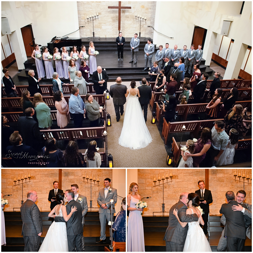 The bride walking down the aisle with both of her dads.