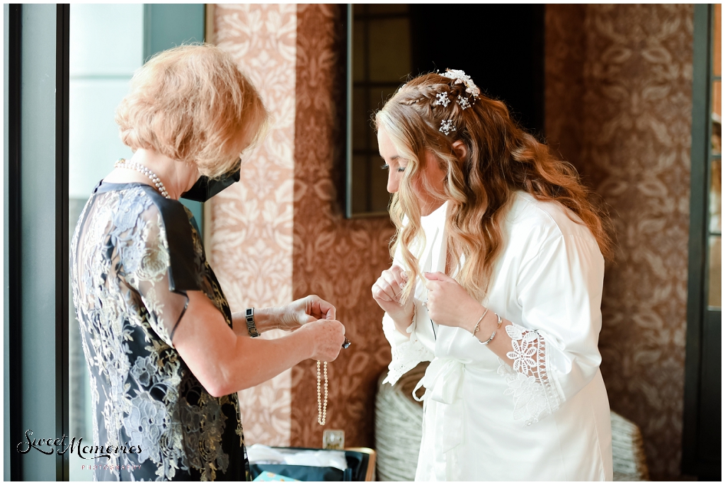 The groom's mother loaning her pearls to the bride. 