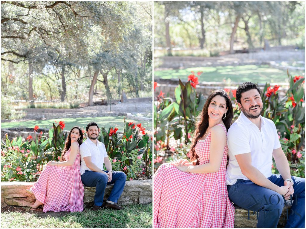 The couple sitting on a stone wall at zilker botanical garden in austin texas.