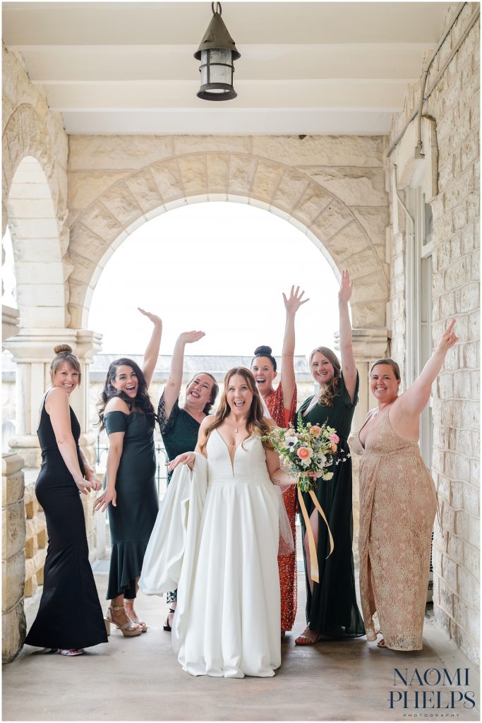 Bride and bridesmaids cheering under the arch at Chateau Bellevue 