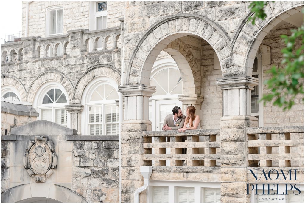 Bride and groom talk under the arch at Chateau Bellevue, one of the best Austin wedding venues.