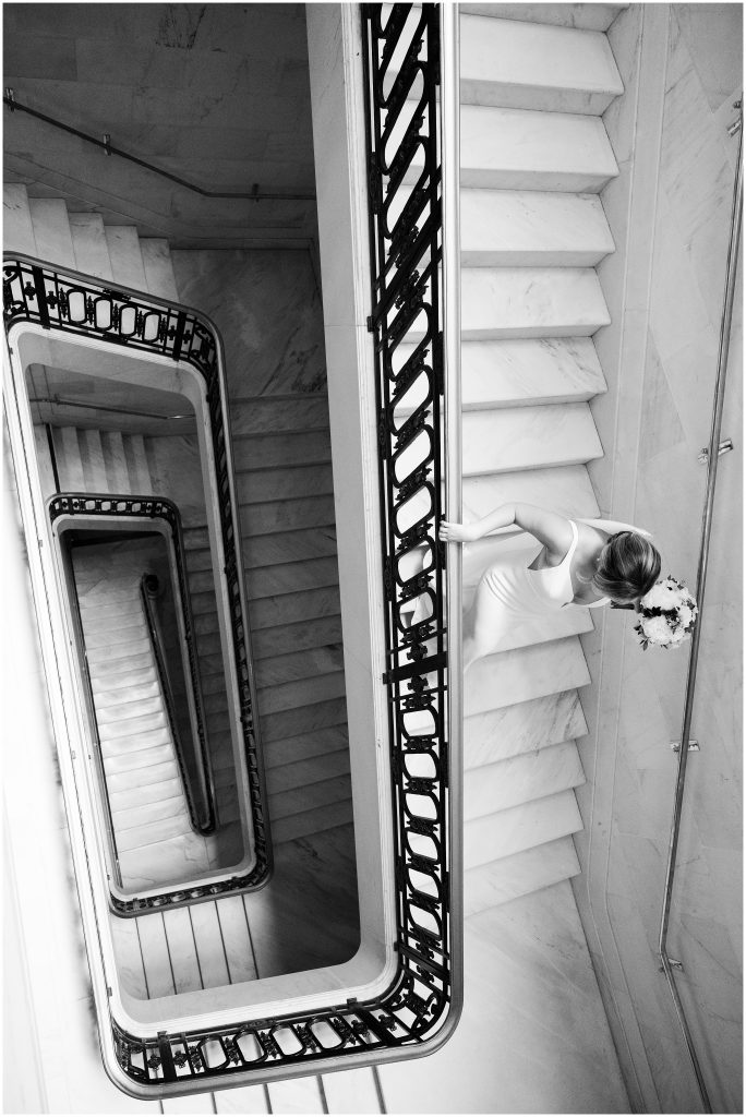 The bride walking down the staircase at San Francisco City Hall 