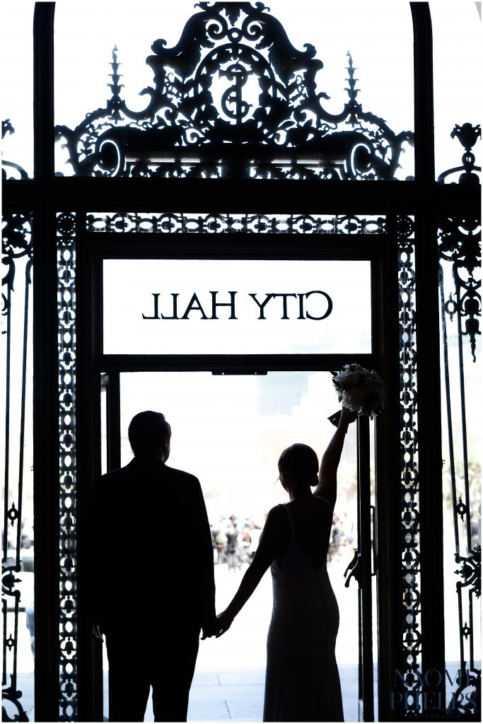 Bride and groom exiting the San Francisco city hall after their wedding ceremony.