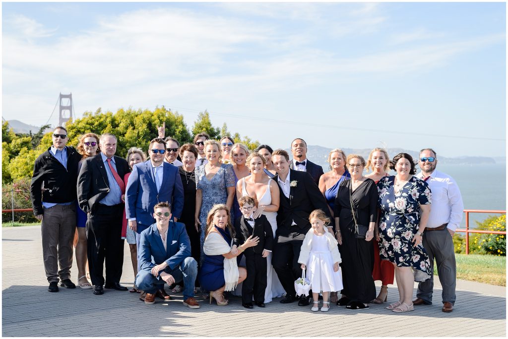 A group photo of all of the wedding guests outside of the Golden Gate bridge.