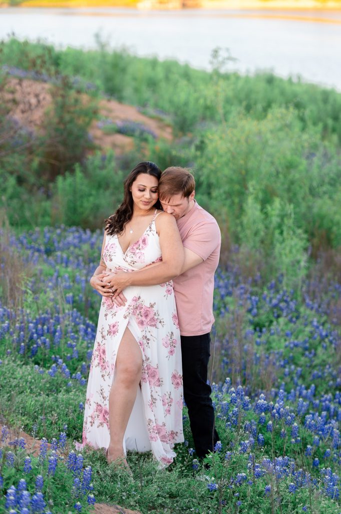 Couple posing in bluebonnet fields for engagement photos in Austin, TX.
