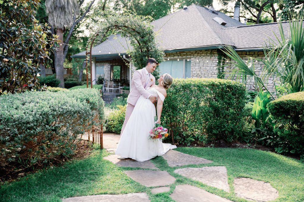 Newlyweds posing in the gardens at The Hummingbird House wedding venue.
