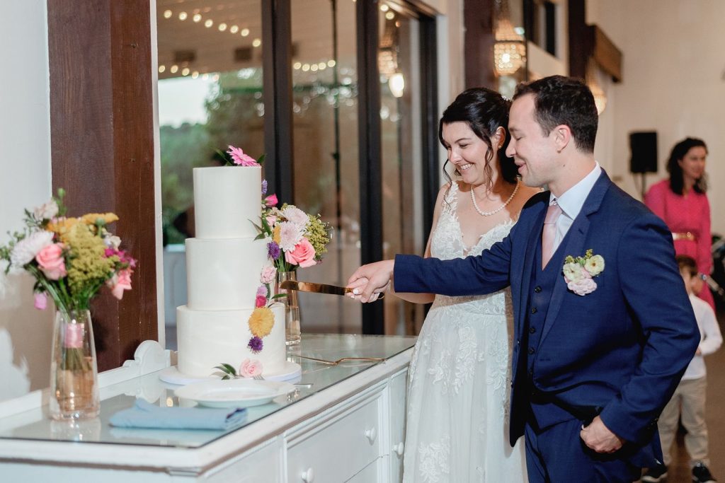 Newlyweds cutting their cake at Pecan Springs Ranch wedding reception.