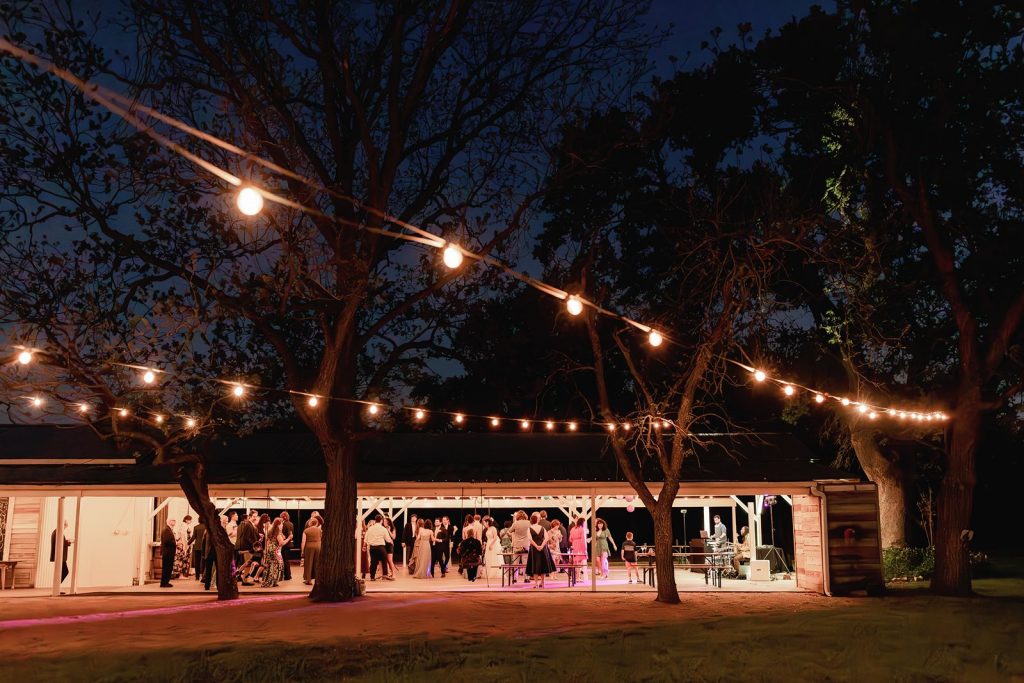 Wide shot of the guests on the patio at Pecan Springs Ranch wedding reception.