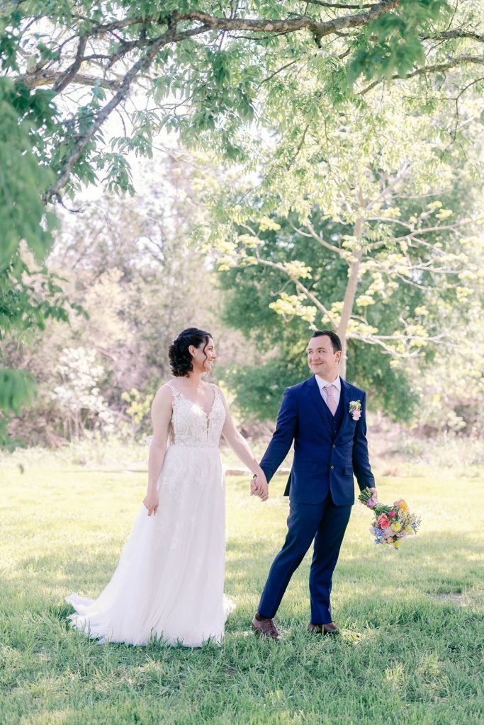 Newlyweds walking through the grounds of Pecan Springs Ranch in Austin Texas.