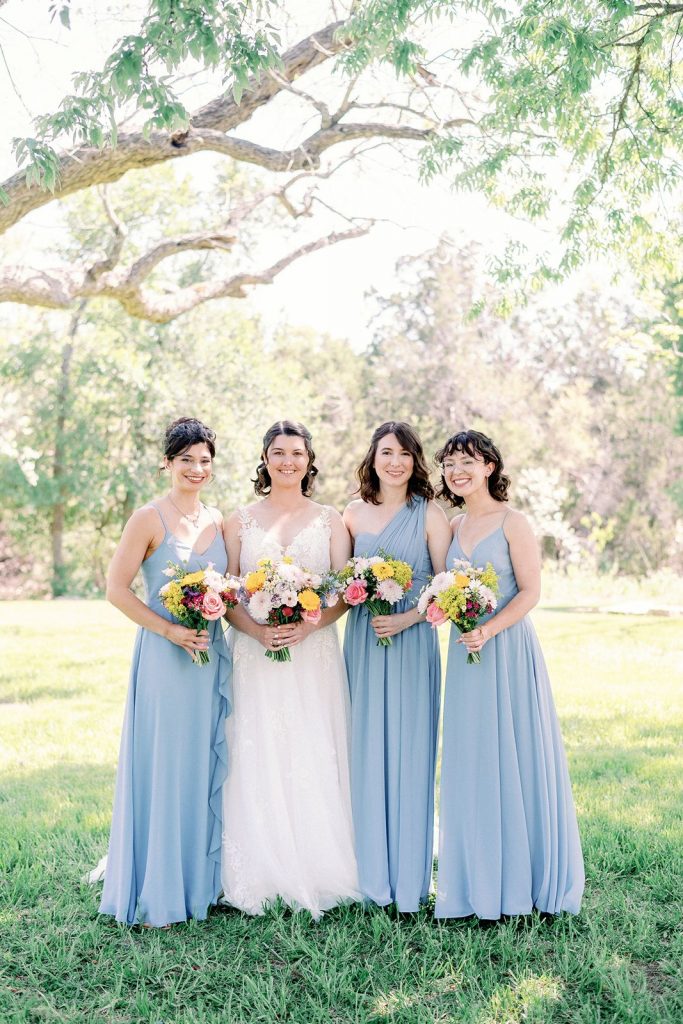 Bride standing with her bridesmaids at Pecan Springs Ranch wedding venue in Austin TX.