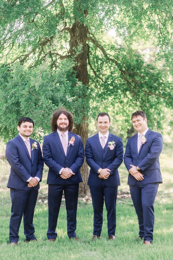Groom standing with his groomsmen at Pecan Springs Ranch wedding venue in Austin TX.