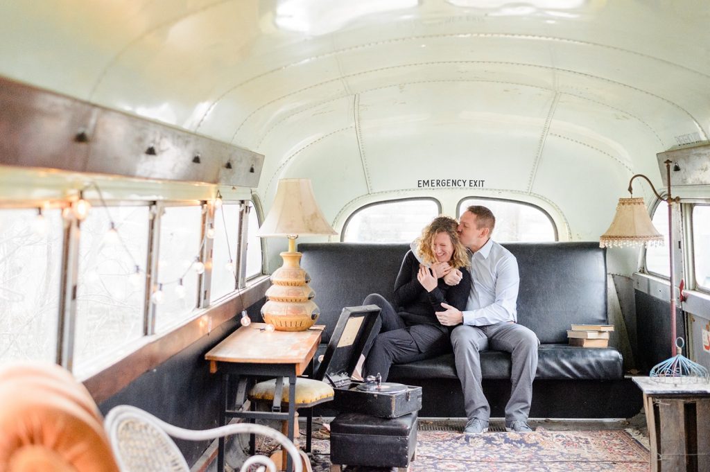 Engaged couple snuggling inside a renovated school bus at Sekrit Theater in Austin, TX.