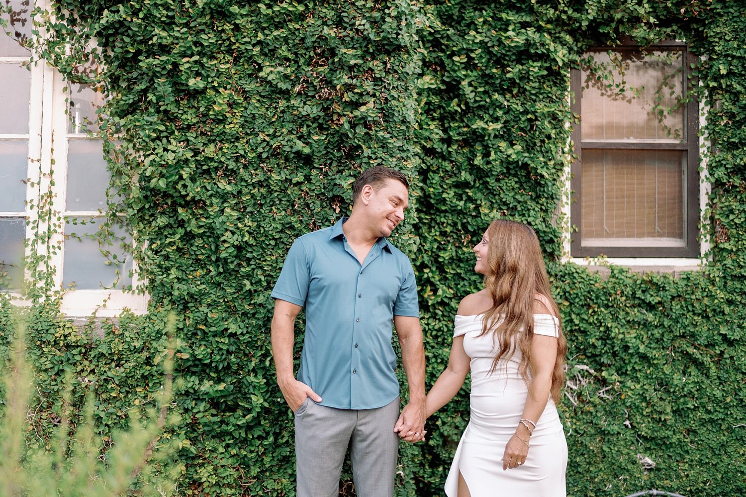 Couples holding hands in front of ivy wall at San Jose Hotel