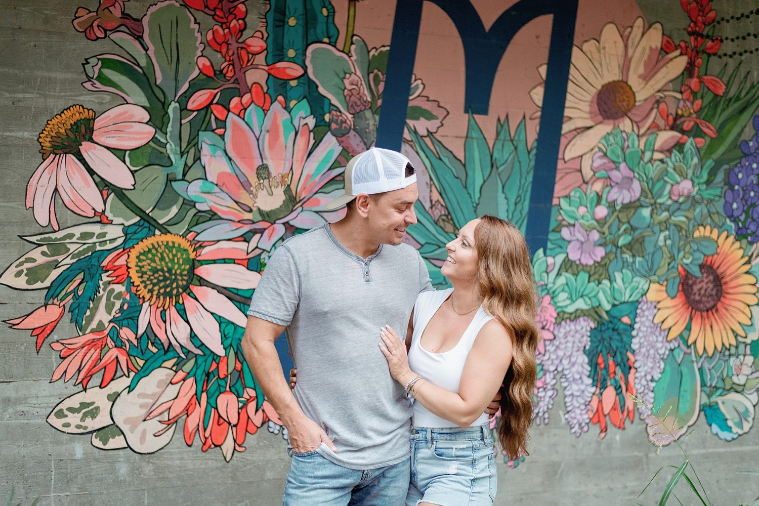 Couple standing in front of floral mural 