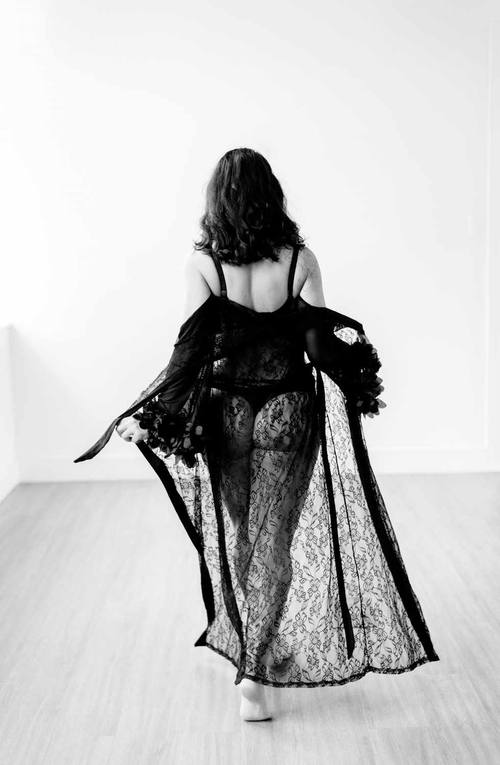 Black and white photo of woman wearing a black lace nightgown for a boudoir photoshoot in Austin