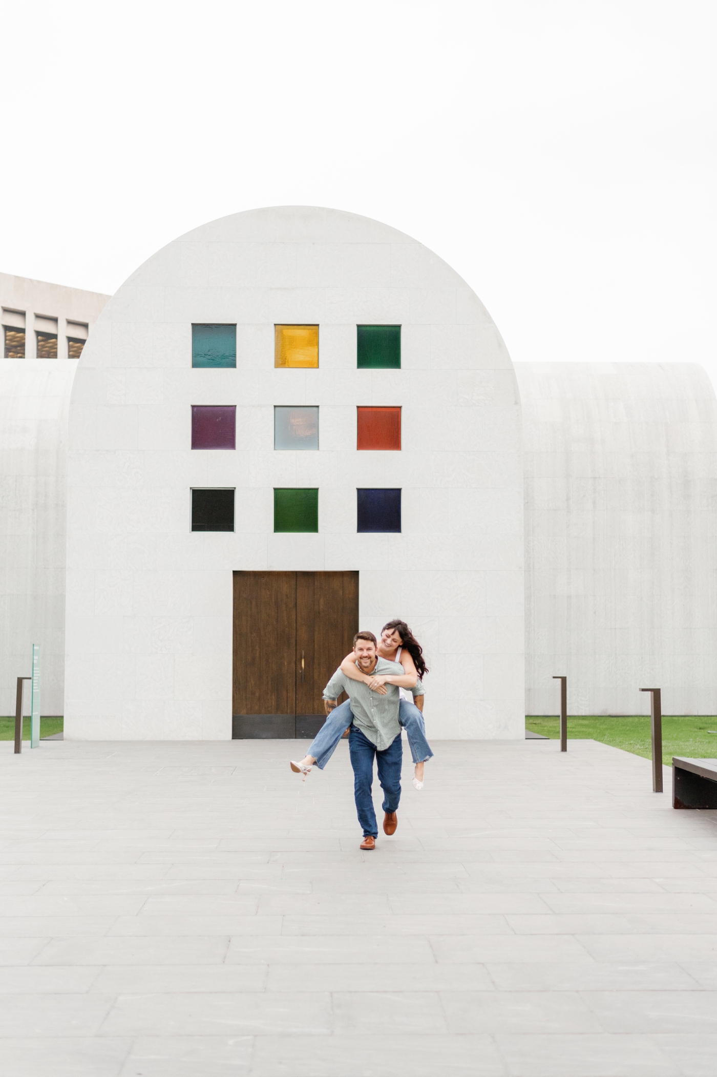 A man in a green shirt gives his fiancée a piggy-back ride